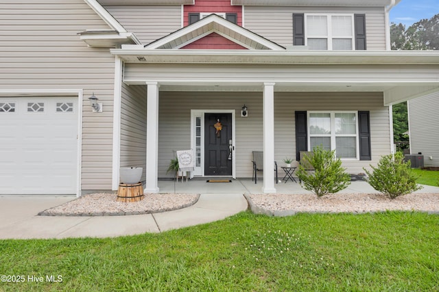 view of front of property featuring a porch, a garage, and central AC