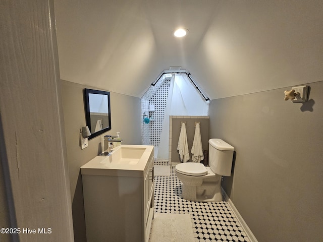 bathroom featuring toilet, lofted ceiling, baseboards, vanity, and a shower