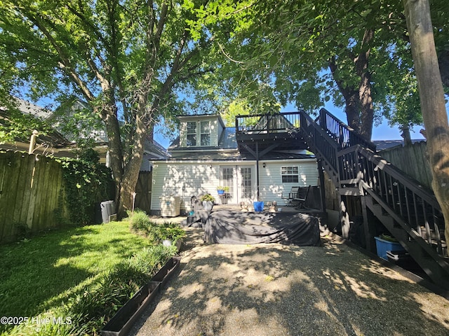 back of property with stairway, a deck, and a patio