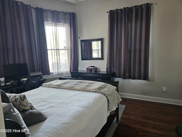 bedroom with dark wood-style flooring and baseboards