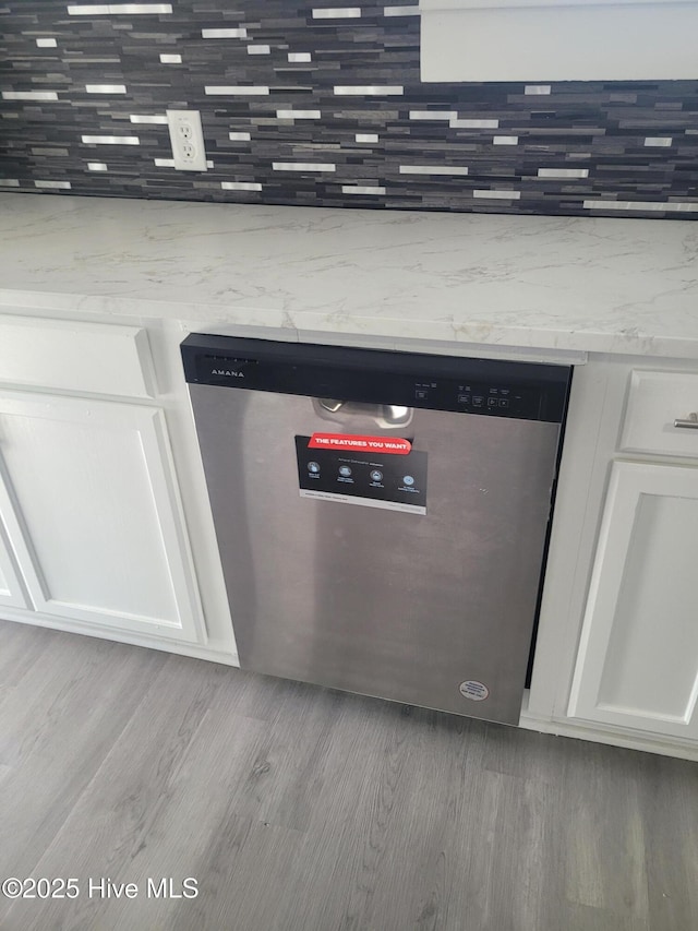 4384 Race Track Rd, Grifton, NC 28530 - detailed view of stainless steel dishwasher, white cabinets, wood finished floors, and decorative backsplash
