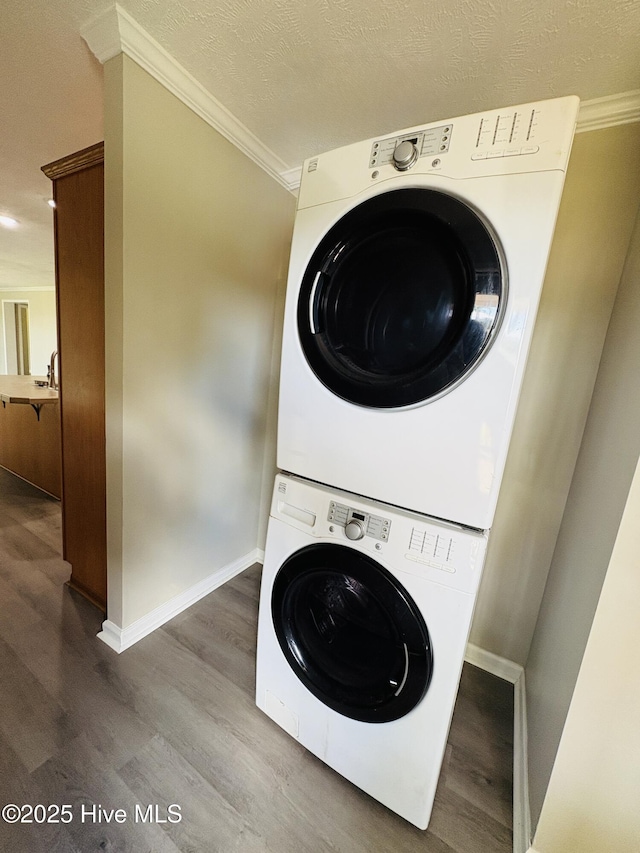 106 Haywood Country Dr, Mount Gilead, NC 27306 - laundry area with stacked washing machine and dryer, wood finished floors, crown molding, baseboards, and a textured ceiling