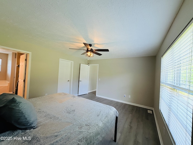 106 Haywood Country Dr, Mount Gilead, NC 27306 - bedroom with dark wood-type flooring, multiple windows, baseboards, ceiling fan, and a textured ceiling
