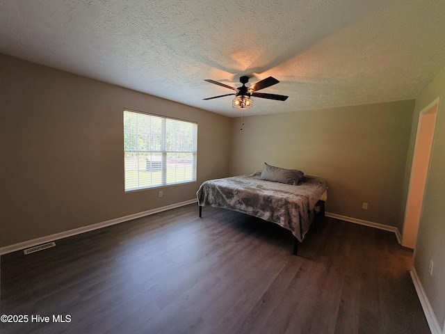 106 Haywood Country Dr, Mount Gilead, NC 27306 - bedroom with dark wood-type flooring, baseboards, ceiling fan, and a textured ceiling