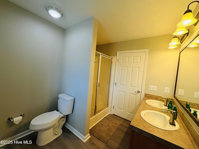 106 Haywood Country Dr, Mount Gilead, NC 27306 - full bath featuring wood finished floors, a shower stall, toilet, double vanity, and baseboards