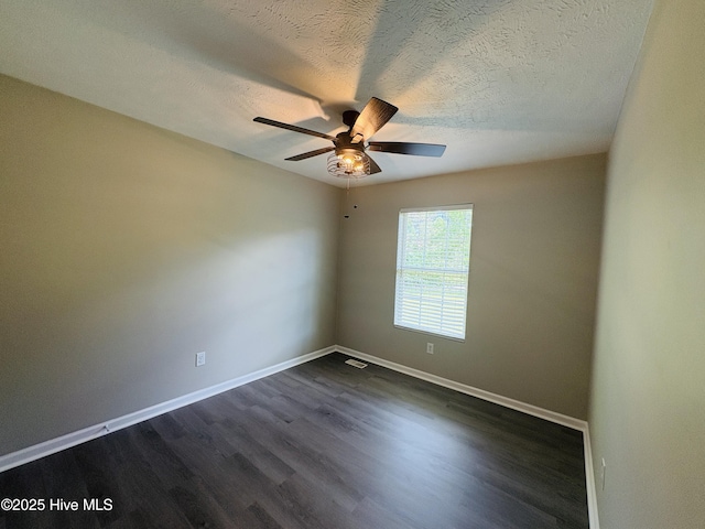 106 Haywood Country Dr, Mount Gilead, NC 27306 - spare room with baseboards, dark wood-type flooring, a ceiling fan, and a textured ceiling