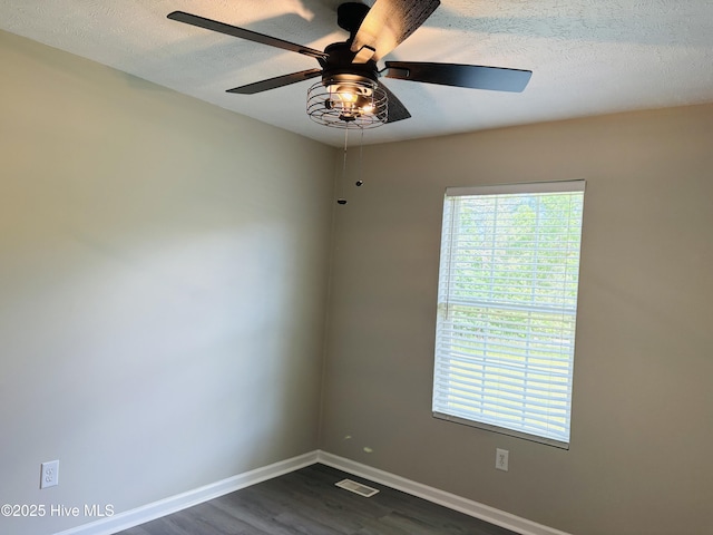 106 Haywood Country Dr, Mount Gilead, NC 27306 - empty room with dark wood-style floors, healthy amount of natural light, a textured ceiling, and baseboards