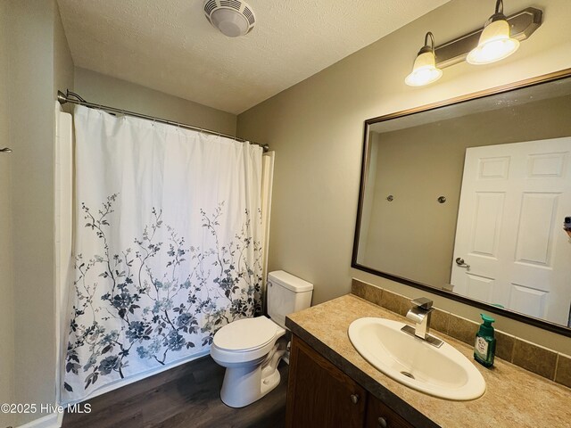 106 Haywood Country Dr, Mount Gilead, NC 27306 - full bath featuring wood finished floors, toilet, vanity, curtained shower, and a textured ceiling
