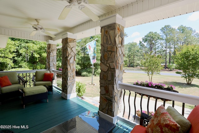wooden terrace with a ceiling fan, covered porch, and outdoor lounge area