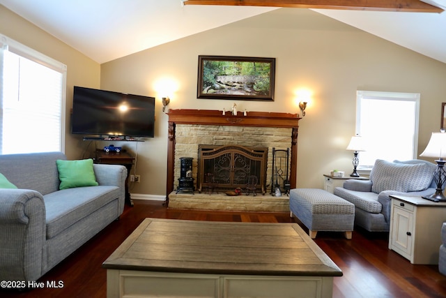 living area featuring vaulted ceiling, dark wood-style floors, a stone fireplace, and baseboards