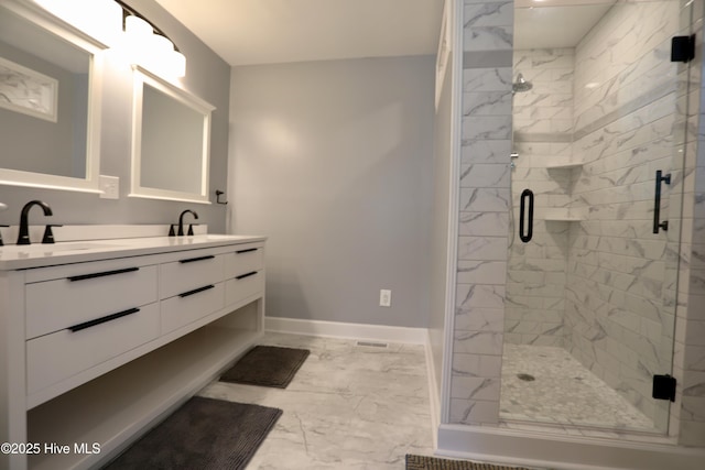 bathroom featuring marble finish flooring, double vanity, a stall shower, and baseboards