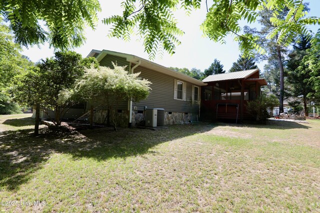view of green lawn featuring central air condition unit