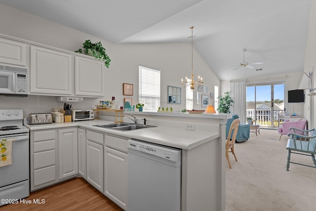 881 Great Egret Cir SW Unit 59E, Sunset Beach, NC 28468 - kitchen featuring white appliances, a peninsula, a sink, white cabinetry, and lofted ceiling