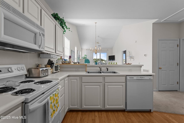 881 Great Egret Cir SW Unit 59E, Sunset Beach, NC 28468 - kitchen featuring white appliances, a sink, a peninsula, light wood finished floors, and a chandelier
