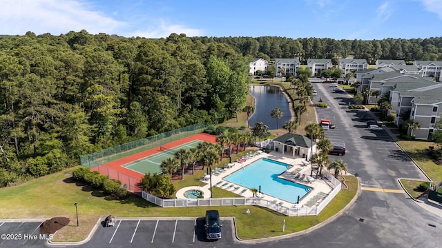 881 Great Egret Cir SW Unit 59E, Sunset Beach, NC 28468 - bird's eye view of a pool, a heavily wooded area, and a large body of water