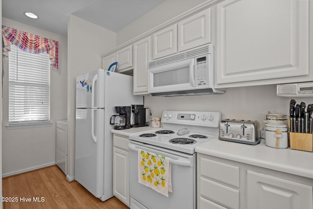 881 Great Egret Cir SW Unit 59E, Sunset Beach, NC 28468 - kitchen with white appliances, white cabinetry, light countertops, washer / clothes dryer, and light wood-style floors