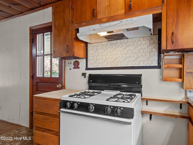 204 Cedar St, Emerald Isle, NC 28594 - kitchen with white gas stove, under cabinet range hood, decorative backsplash, and brown cabinetry