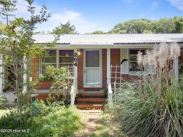 204 Cedar St, Emerald Isle, NC 28594 - view of front of house featuring brick siding and metal roof