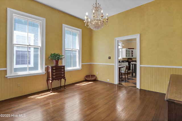 211 Ann St, Wilmington, NC 28401 - spare room with a chandelier, wood-type flooring, and wainscoting