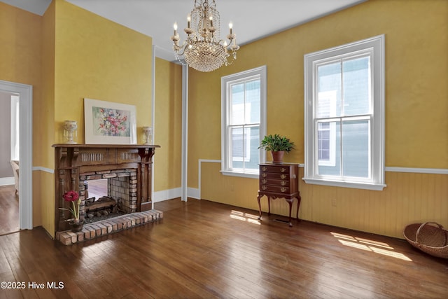 211 Ann St, Wilmington, NC 28401 - living area featuring hardwood / wood-style floors, a chandelier, a wainscoted wall, and a brick fireplace