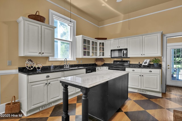 211 Ann St, Wilmington, NC 28401 - kitchen with black appliances, white cabinets, glass insert cabinets, hanging light fixtures, and a sink