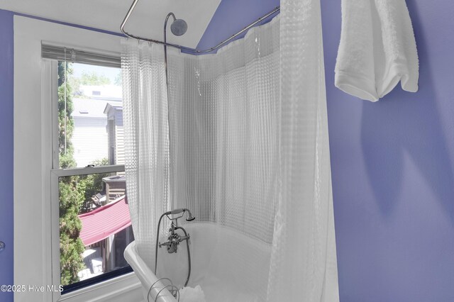 211 Ann St, Wilmington, NC 28401 - bathroom featuring a soaking tub, a shower with shower curtain, and lofted ceiling