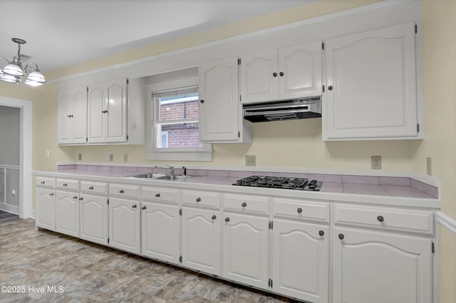 211 Ann St, Wilmington, NC 28401 - kitchen featuring a sink, under cabinet range hood, black gas stovetop, white cabinetry, and decorative light fixtures