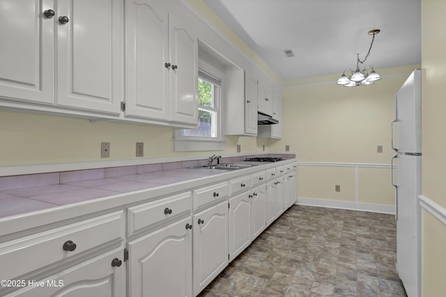 211 Ann St, Wilmington, NC 28401 - kitchen with freestanding refrigerator, a sink, white cabinets, and cooktop