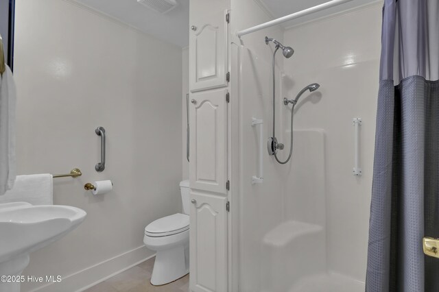 211 Ann St, Wilmington, NC 28401 - full bathroom featuring a stall shower, toilet, baseboards, and a sink