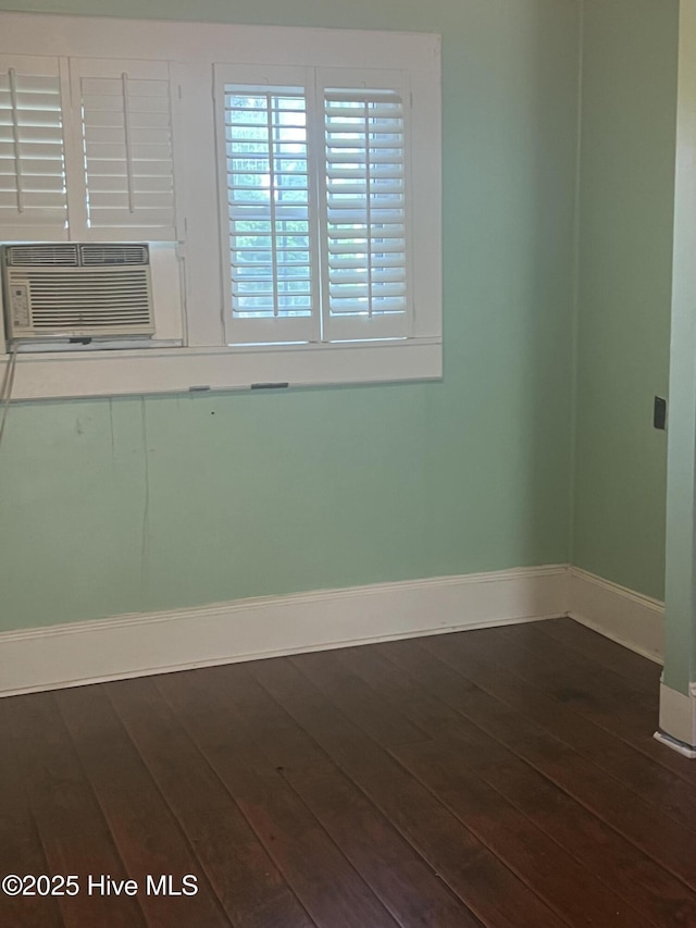 unfurnished room featuring dark wood-type flooring, baseboards, and cooling unit