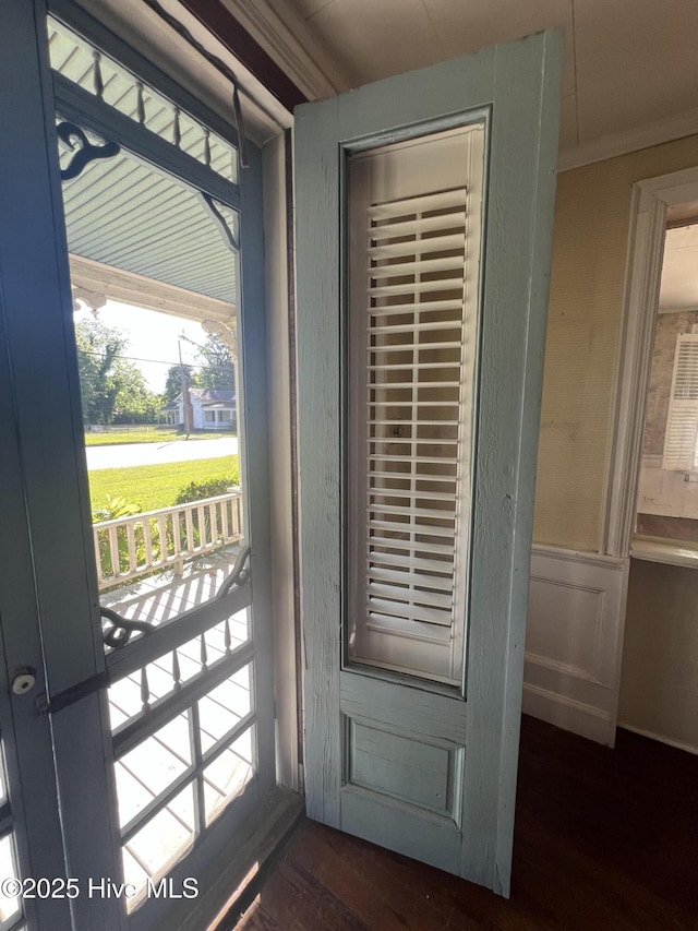 doorway to outside featuring crown molding, dark wood finished floors, and healthy amount of natural light