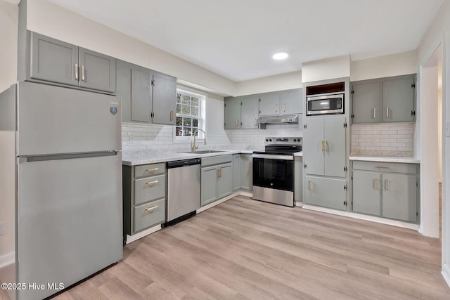 304 S Thompson St, Whiteville, NC 28472 - kitchen with appliances with stainless steel finishes, gray cabinetry, a sink, under cabinet range hood, and light countertops