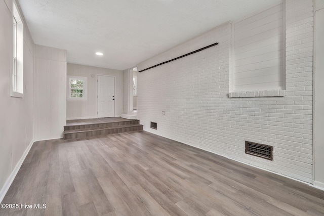 304 S Thompson St, Whiteville, NC 28472 - unfurnished living room featuring wood finished floors, baseboards, recessed lighting, and brick wall