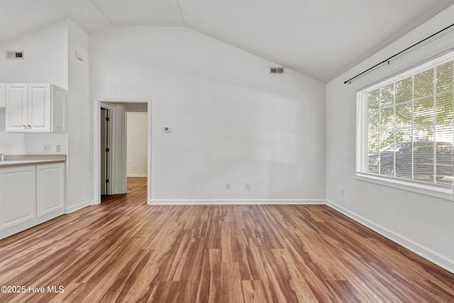 1119 Park St 1117, Elizabeth City, NC 27909 - unfurnished living room with lofted ceiling, light wood-type flooring, and baseboards