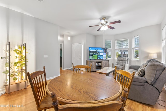 dining room with ceiling fan, light wood-style floors, and baseboards
