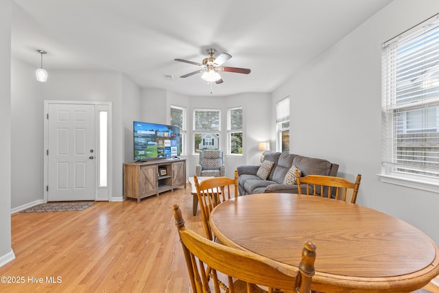 dining room with a ceiling fan, light wood-style floors, and baseboards
