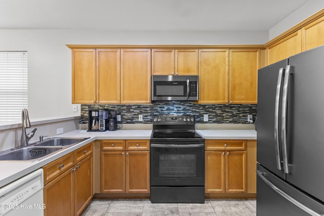kitchen with stainless steel appliances, a sink, light countertops, and decorative backsplash