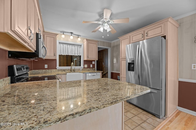 kitchen with appliances with stainless steel finishes, a sink, light brown cabinets, ceiling fan, and light stone countertops