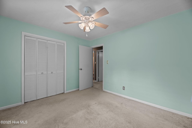 unfurnished bedroom with carpet, baseboards, a closet, and ceiling fan