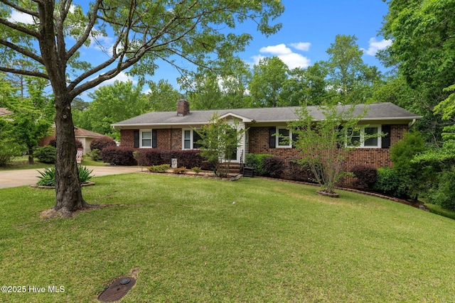 ranch-style home with a chimney, brick siding, and a front lawn
