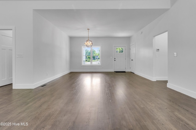140 E Ag Dr, New Bern, NC 28562 - unfurnished living room with a chandelier, baseboards, and dark wood-type flooring