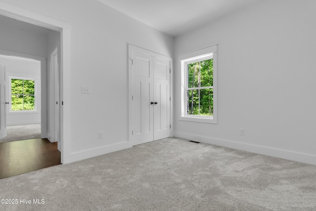 140 E Ag Dr, New Bern, NC 28562 - unfurnished bedroom featuring multiple windows, carpet, and baseboards