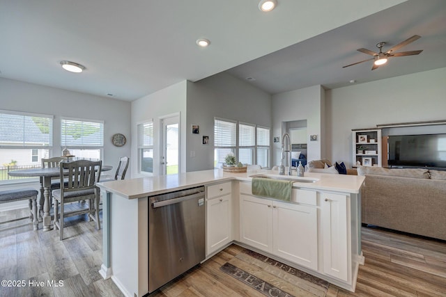 6909 English Holly Ct SW, Ocean Isle Beach, NC 28469 - kitchen featuring stainless steel dishwasher, open floor plan, a sink, light countertops, and light wood-type flooring
