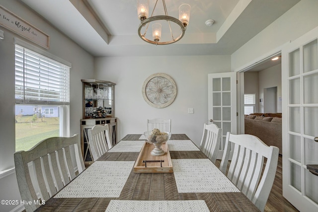 6909 English Holly Ct SW, Ocean Isle Beach, NC 28469 - dining area with a chandelier, healthy amount of natural light, a raised ceiling, and french doors