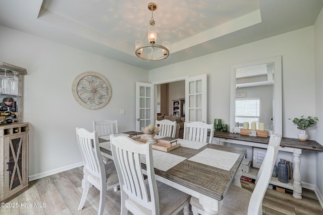 6909 English Holly Ct SW, Ocean Isle Beach, NC 28469 - dining room with a raised ceiling, french doors, and light wood-style floors