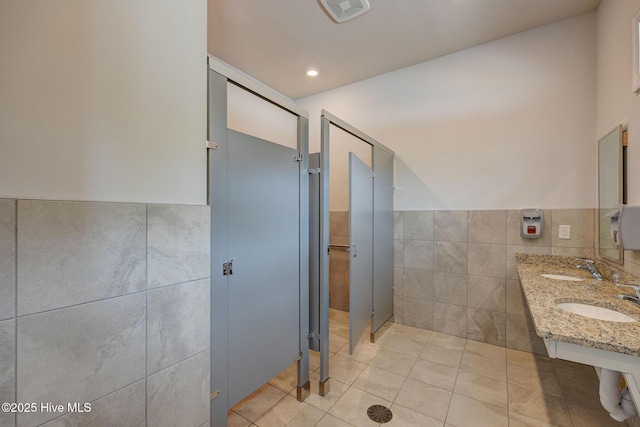 6909 English Holly Ct SW, Ocean Isle Beach, NC 28469 - full bathroom with tile walls, a sink, tile patterned floors, and a wainscoted wall