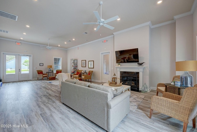 6909 English Holly Ct SW, Ocean Isle Beach, NC 28469 - living area featuring ceiling fan, recessed lighting, light wood-type flooring, a glass covered fireplace, and crown molding