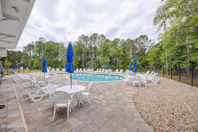6909 English Holly Ct SW, Ocean Isle Beach, NC 28469 - community pool with fence, a patio area, and view of scattered trees