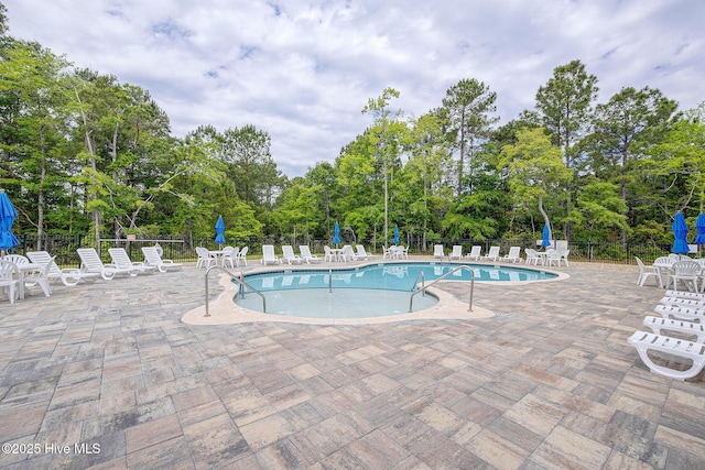 6909 English Holly Ct SW, Ocean Isle Beach, NC 28469 - community pool featuring fence, a patio, and view of scattered trees
