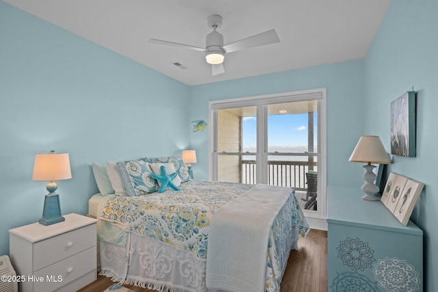 bedroom with access to outside, wood finished floors, and a ceiling fan